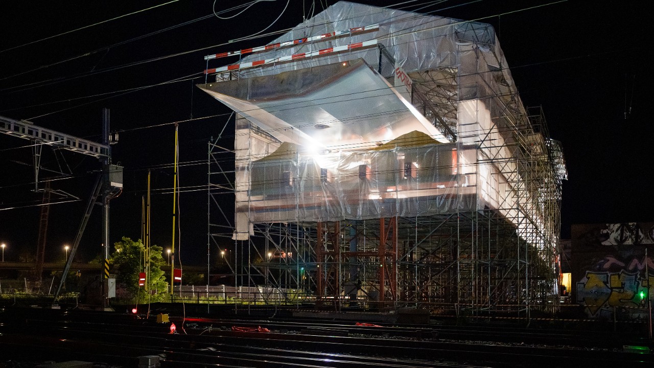 Von einer Installationsplattform aus wird die Passerelle über die Gleise geschoben.