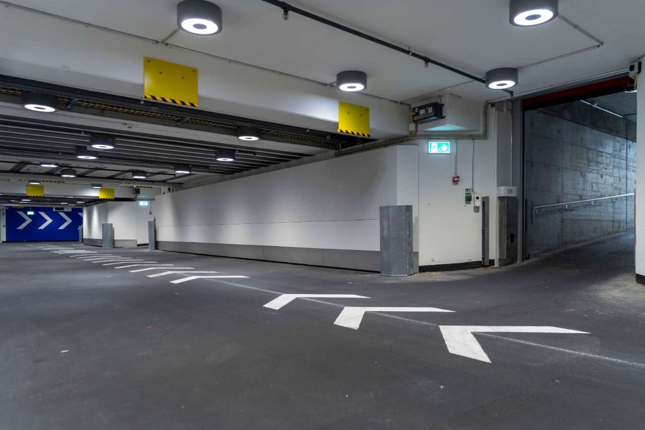 Das Foto zeigt den Übergang vom Rampenabgang in die Unterführung bei geöffnetem Rolltor, von der Unterführung aus gesehen.
