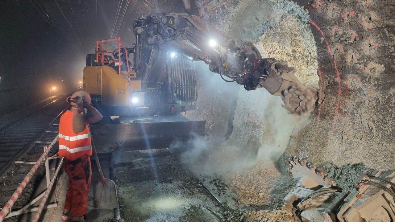 Das Foto zeigt einen Bagger, welcher das Gewölbe des Hauenstein-Basistunnel abträgt.